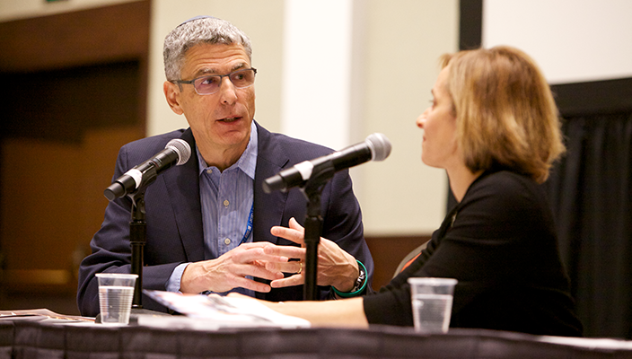 Rabbi Rick Jacobs talks to Rabbi Judy Schindler in front of microphones