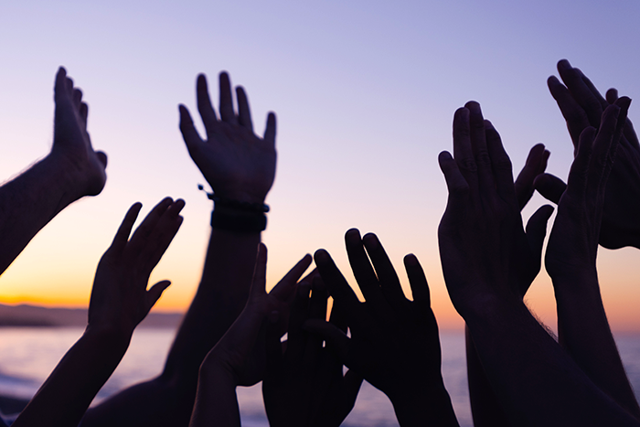 people raising their hands in the air