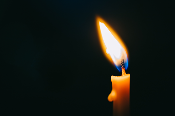 burning candle on black background