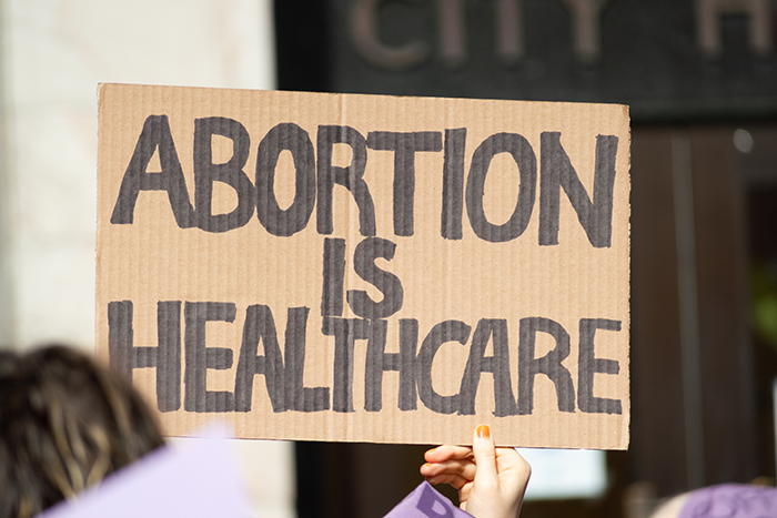 a hand holding a sign supporting prochoice sign says abortion is healthcare