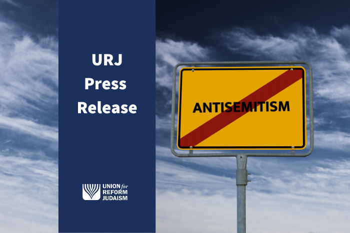 an image with a yellow sign that says antisemitism in black and a red slash crossing it out. The image says URJ Press Release with the URJ logo.