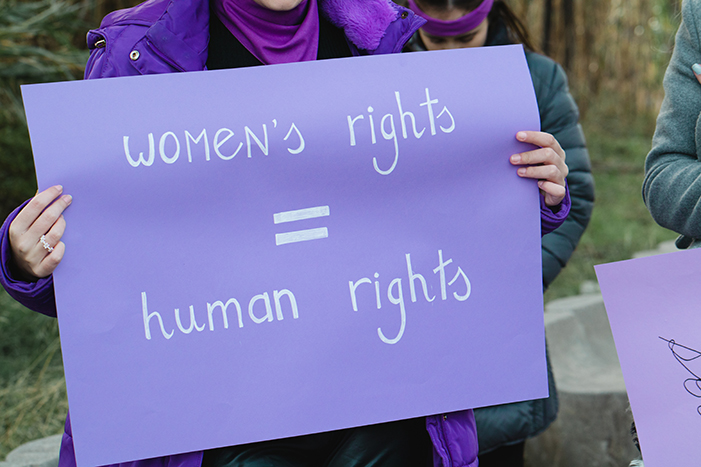 woman holding sign that says womens rights equal human rights
