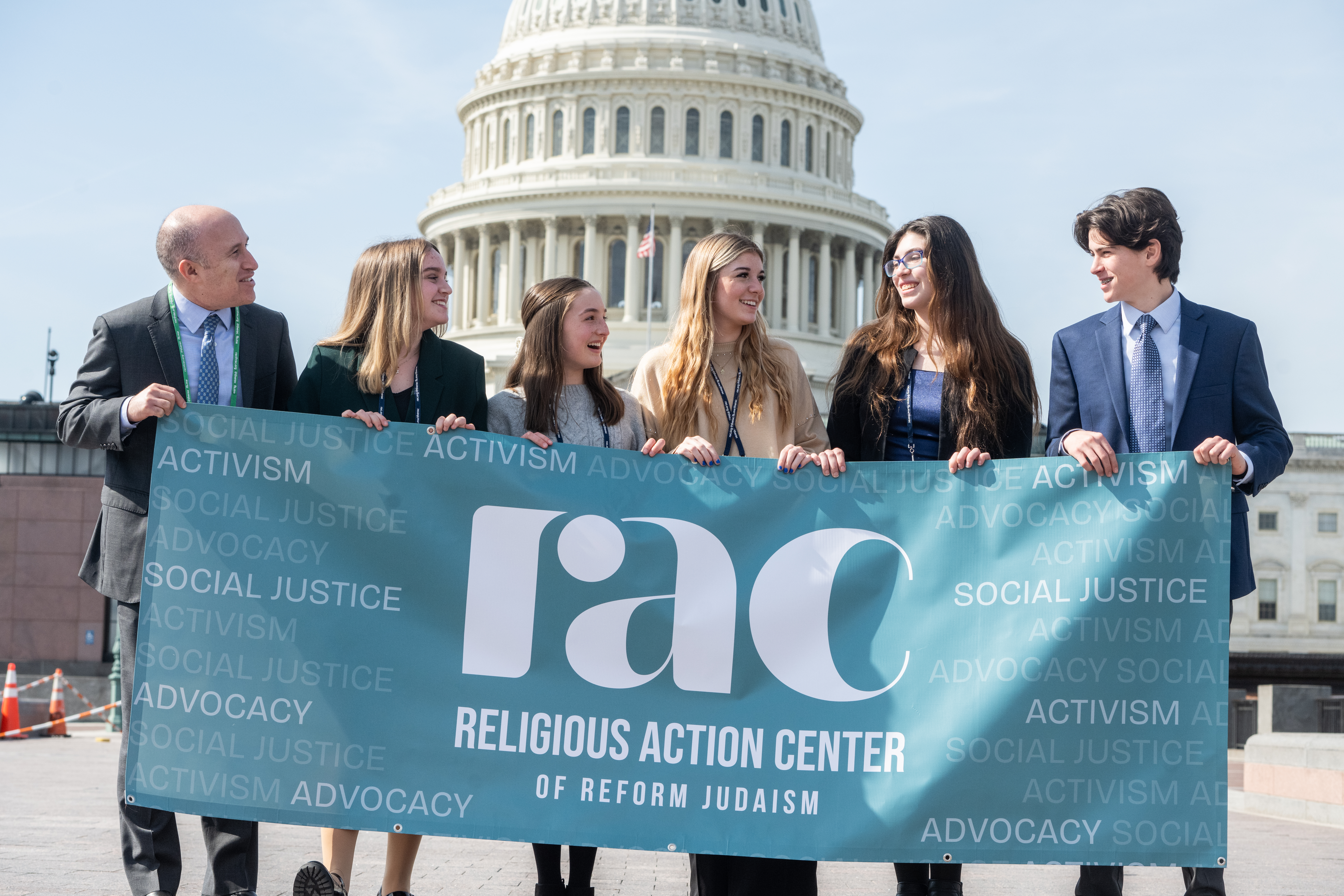 Photograph of L'Taken teens in front of the Capitol Building holding the RAC banner.