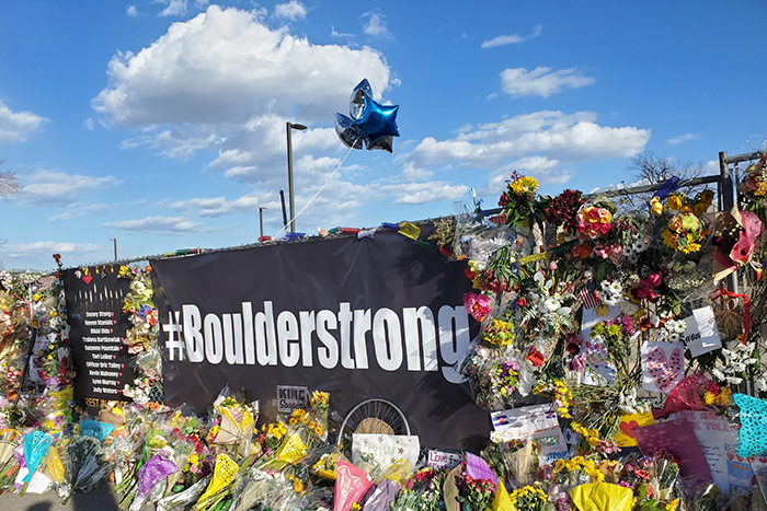 Photo of a memorial in Boulder, CO following an attack on a march in Boulder; says #Boulderstrong with lots of flowers and pictures