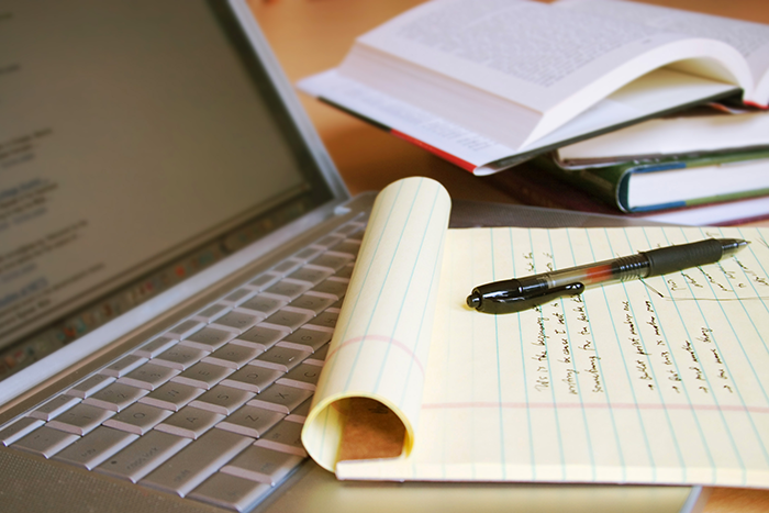 a pen and a letter sitting on top of a laptop