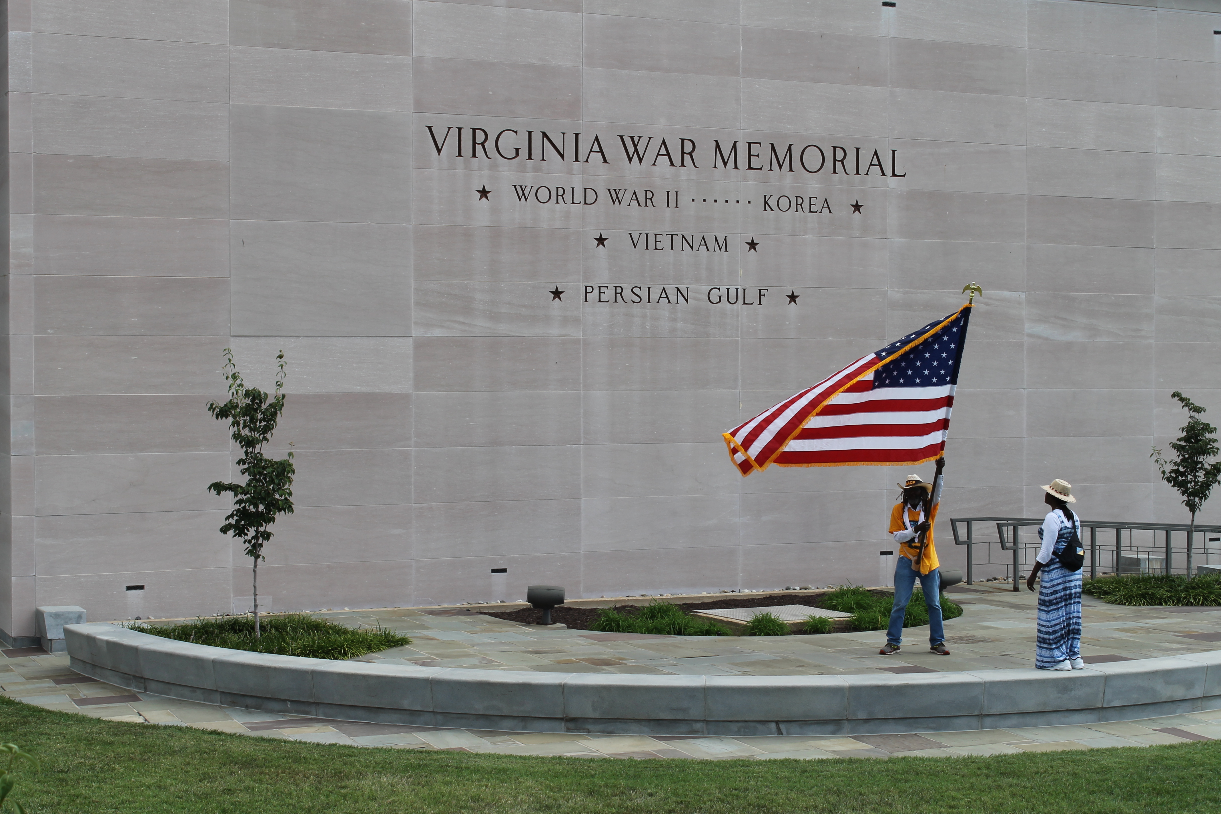 Middle Passage waving American flag in front of the Virginia war memorial