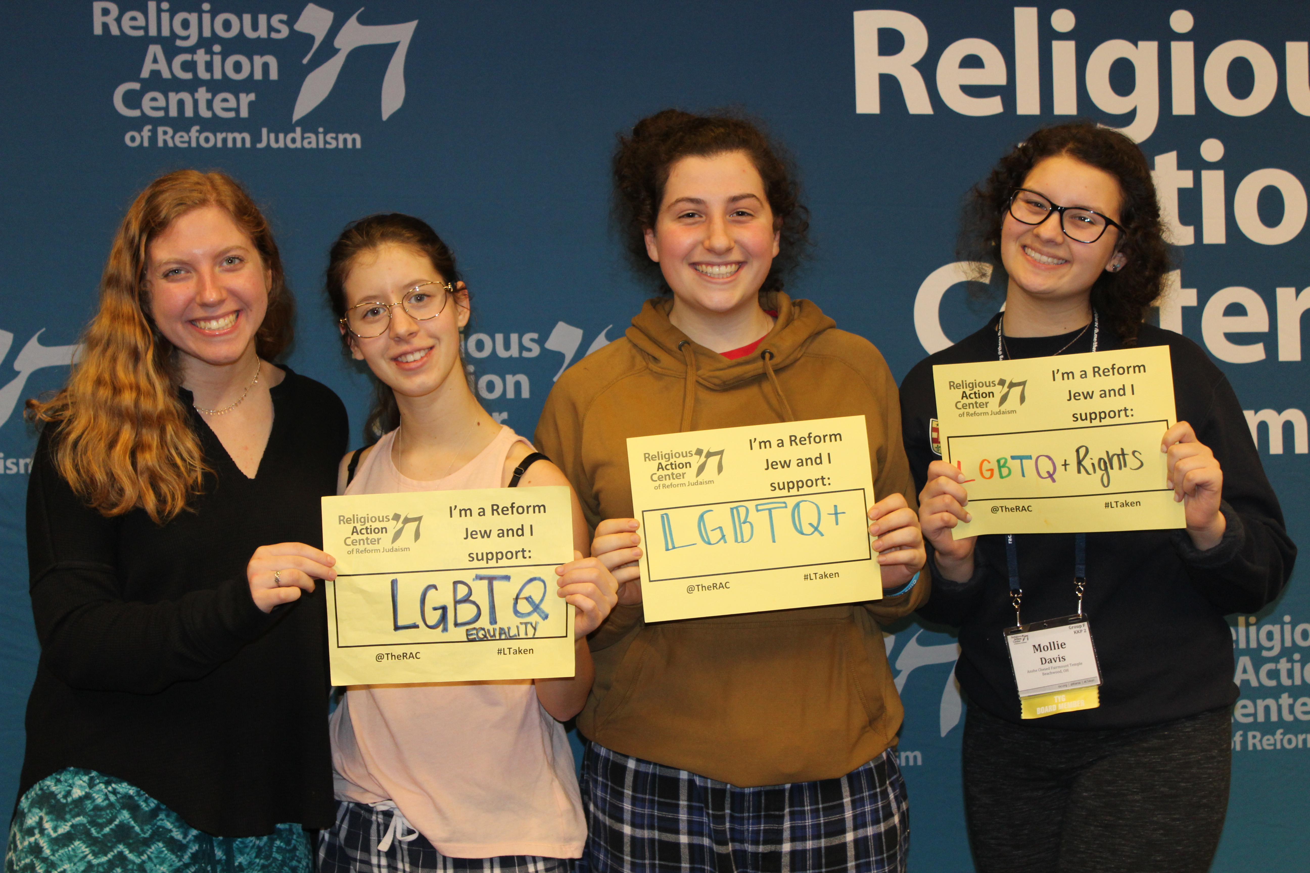 Teens holding signs in support of LGBTQ equality 