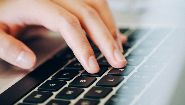 Fingers typing on a laptop keyboard
