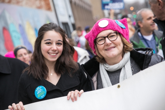 Two women wearing Justice buttons at a womens march