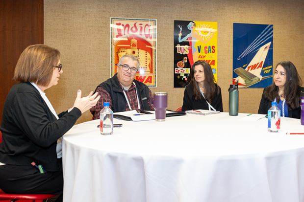 Photo of a group of people sitting at a table talking