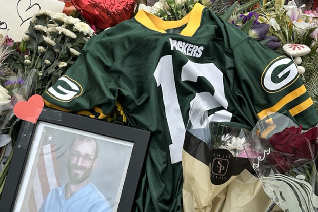 Photo of a memorial for Alex Pretti; photo shows a Green Bay Packers jersey and a framed image of him