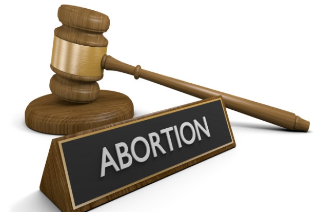 Judge's gavel, sound block, and name plate that says "ABORTION"