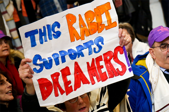 Protester carrying sign that says This Rabbi Supports Dreamers