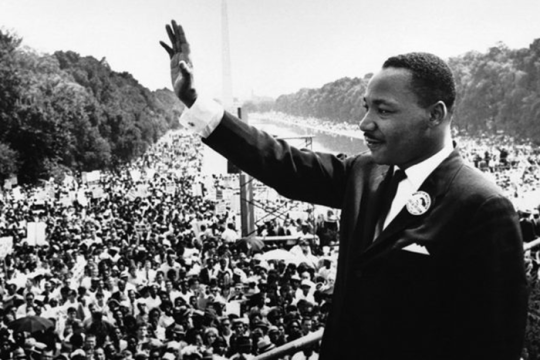an image of Martin Luther King Jr. Waving in front of a group of people