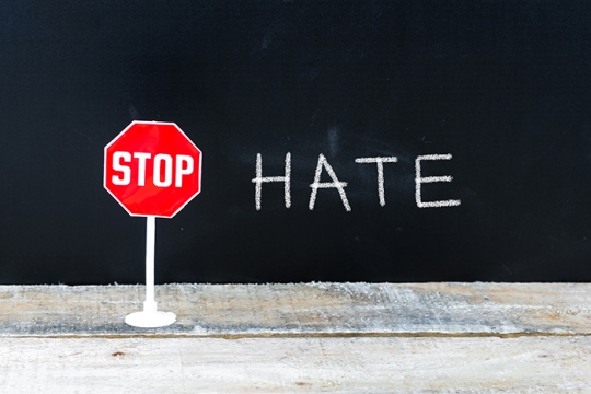 Stop sign with the word HATE next to it