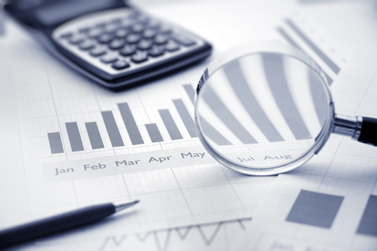 a black and white image of calculator, pen and magnifing glass