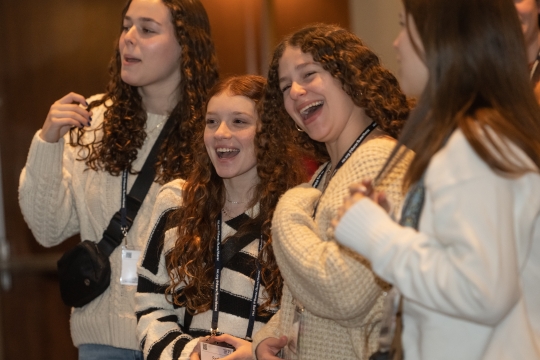 Students standing together, smiling and singing