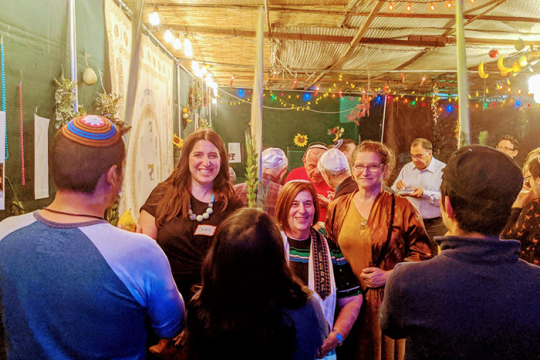 Photo of people standing in a Sukkah