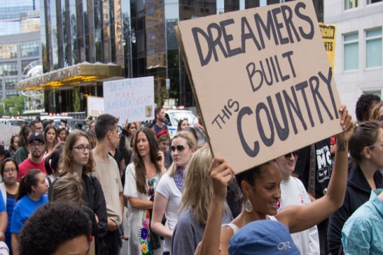 DACA rally in NYC with a marcher holding a sign that says Dreamers built this country.