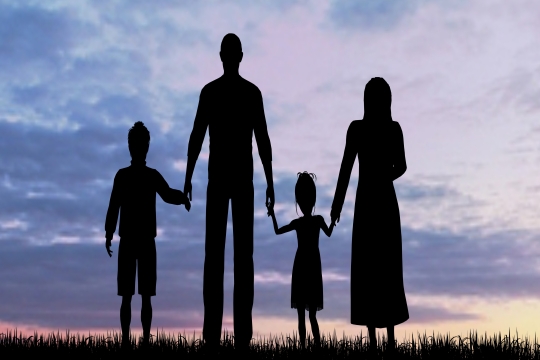 A family standing in silhouette against a sunset