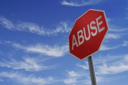 Stop sign with the word Abuse written on it