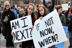Two female students holding gun violence prevention signs at a march 