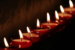 Line of red tealight candles lit in the dark 