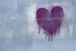 Dripping spray paint heart on a concrete wall 