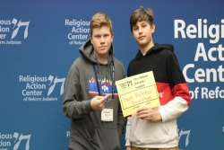 Two Jewish teen boys holding a sign that says I Am a Reform Jewish and I Support Gun Violence Prevention