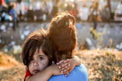 refugee child held by adult