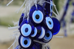 Blue and white glass evil eye amulets hanging together in a bundle 