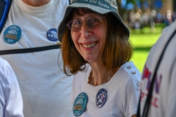 Woman smiling at the camera while wearing Jewish social justice buttons on her shirt