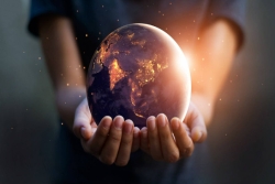 Hands holding a glowing globe 