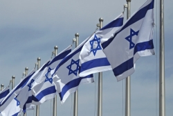 Row of Israeli flags on flagpoles, blowing in the breeze