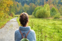 view of woman from the back on an asphalt nature trail 