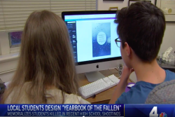 Shows a video still from a local news story about the yearbook, viewer sees back of two students heads with "yearbook of the fallen" displayed on a computer screen
