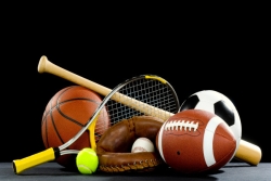Array of sports equipment, incluing tennis racket and ball, baseball in a glove, baseball bat, football, soccer ball, and basketball