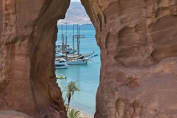 View through a rock formation of water and boats