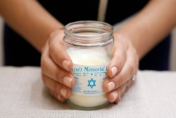 Womans hands holding a Yahrzeit candle 
